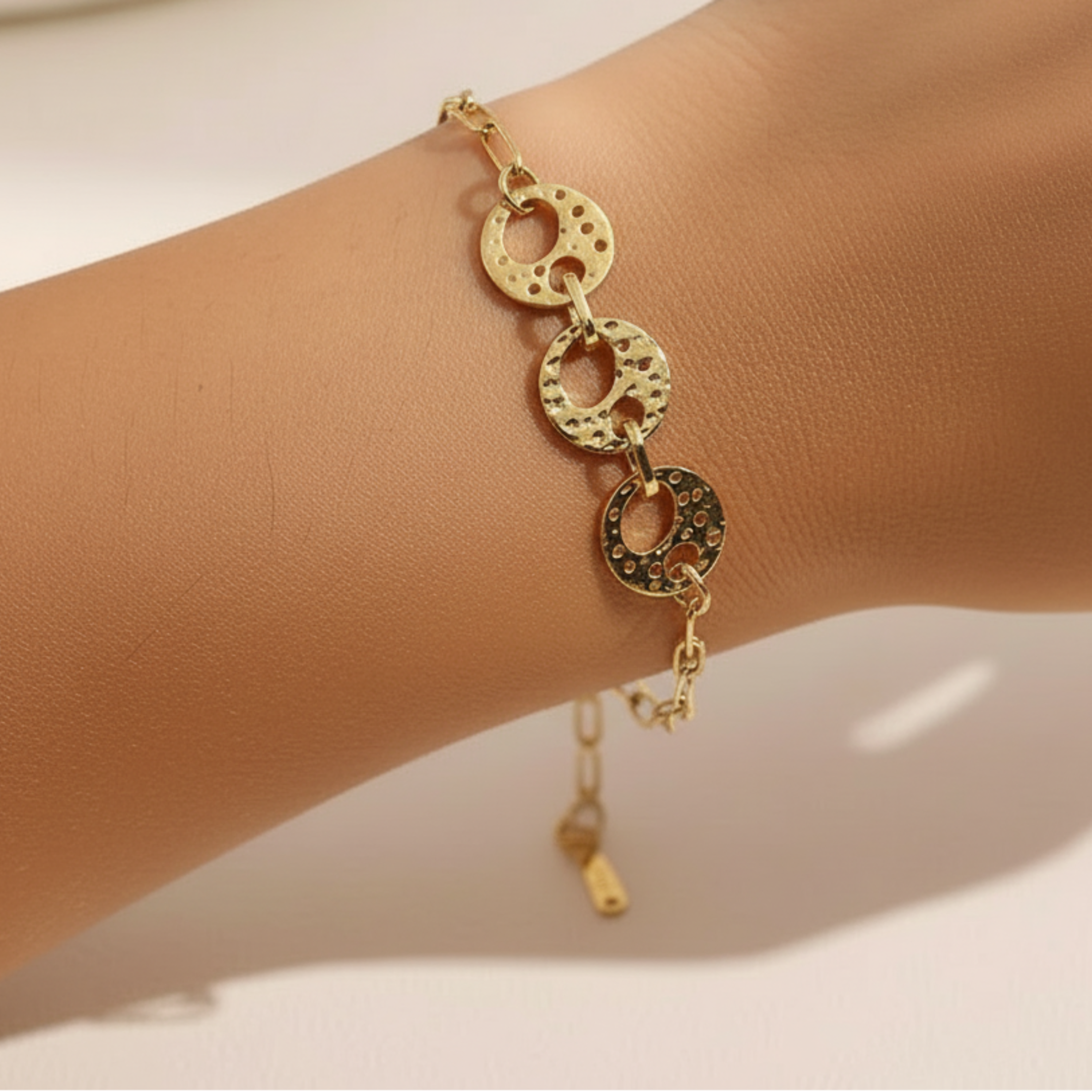 Bracelet Nora porté, maillons martelés dorés cercles percés, acier inoxydable, style artisanal élégant
