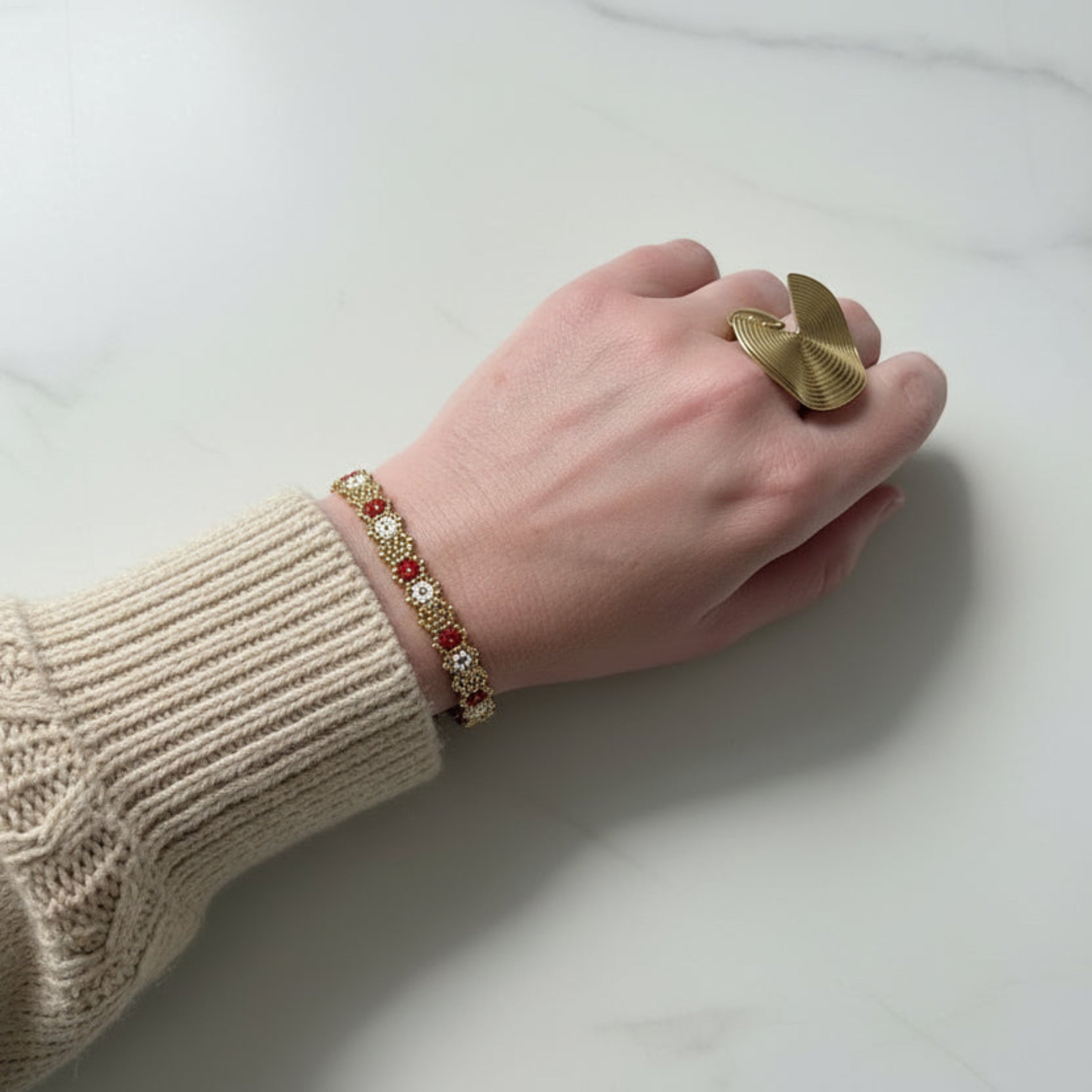 Bracelet fait main Owen ÔParis porté au poignet — perles Miyuki motifs floraux coloris bordeaux, chaîne acier inoxydable doré