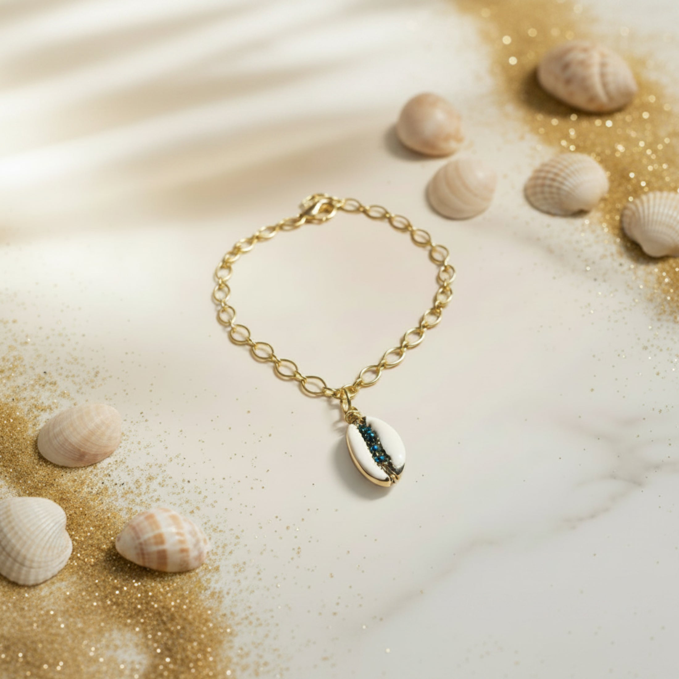 Collier chaîne ovale dorée acier inoxydable, pendentif cauri naturel serti de toupies 2mm bleu nuit, longueur 55cm avec rallonge.
