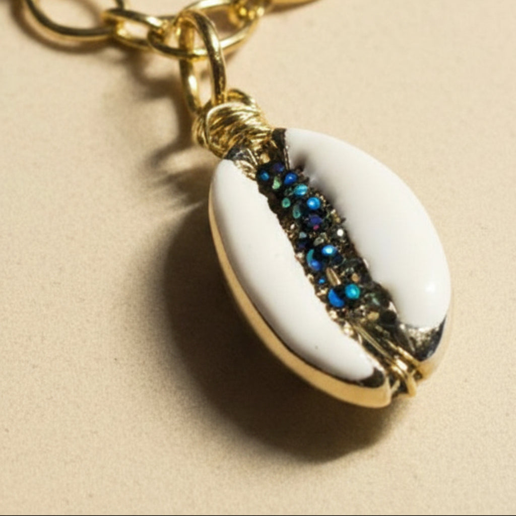 Pendentif cauri naturel serti à la main de mini toupies 2mm bleu nuit, monture dorée acier inoxydable.