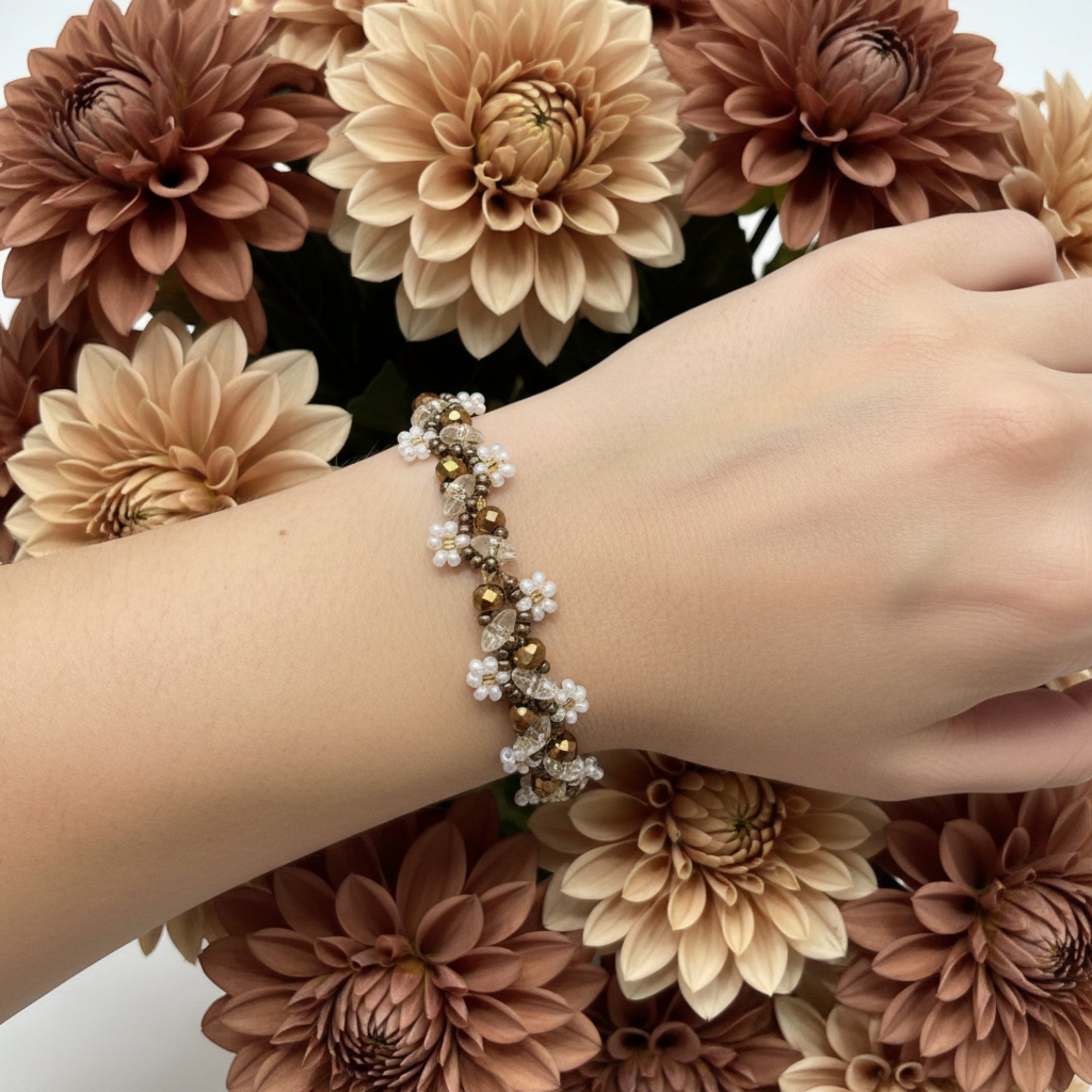 Bracelet Dahlia tissé main porté au poignet, perles verre facettes bronze et champagne, rocailles blanc cristal et dorées, fermoir doré ajustable