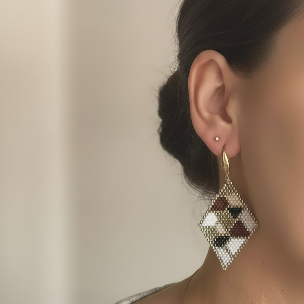 Boucles d'oreilles Paloma ÔParis portées, tissage Miyuki Delica motif géométrique beige rosé et brun doré, longueur 6 cm, finition crochet doré.