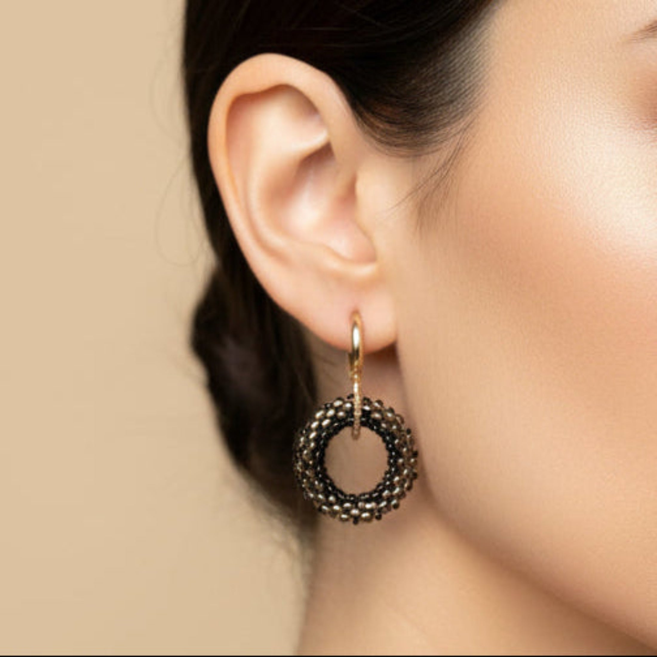 Boucles d'oreilles Selene ÔParis portées, anneau Miyuki Delica noir et anthracite sur mini créole dorée, finition minimaliste, longueur 3,5 cm.