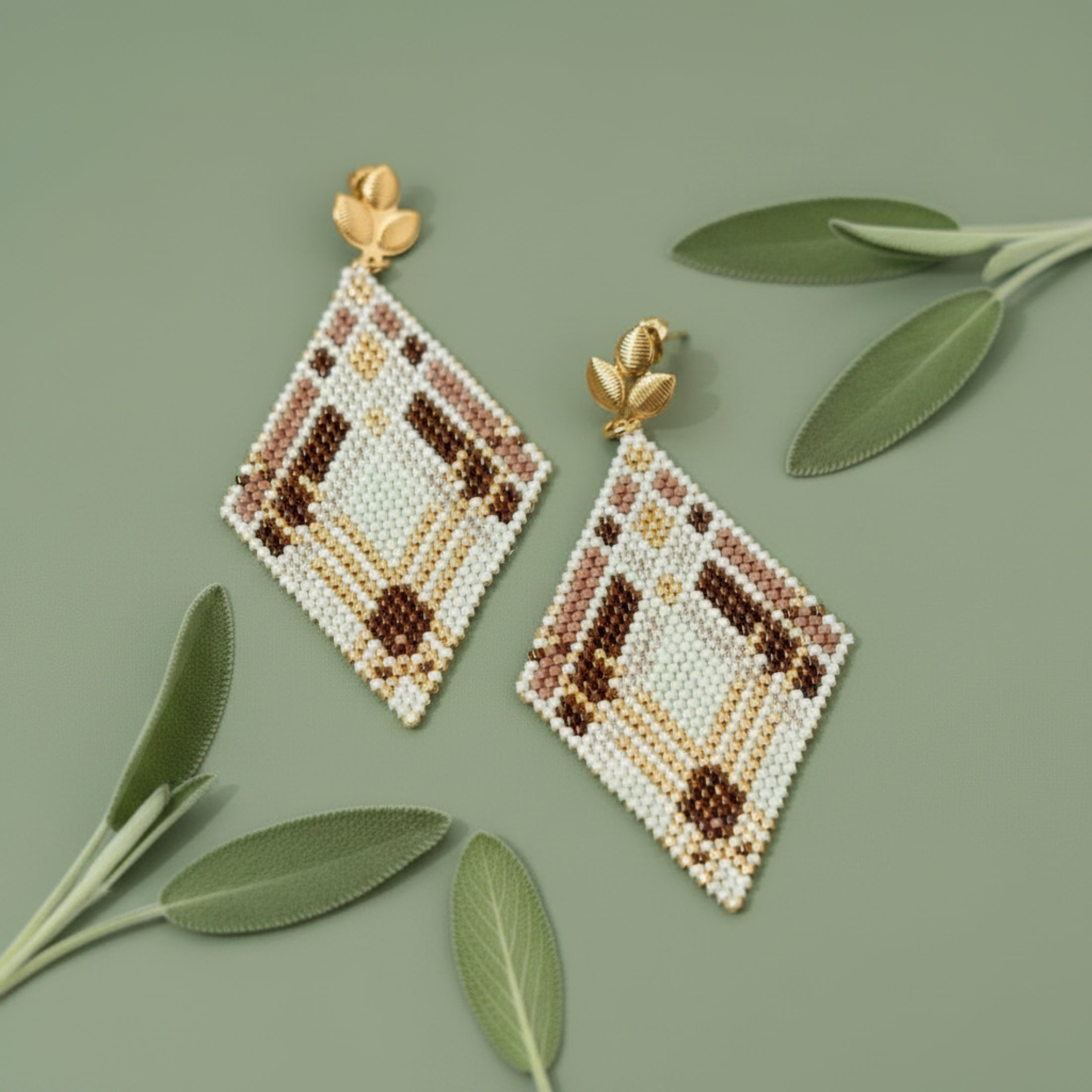 Boucles d'oreilles losange en perles Miyuki vert doré, deux tons marron et blanc cassé, monture dorée motif feuille, motif géométrique tissé main.