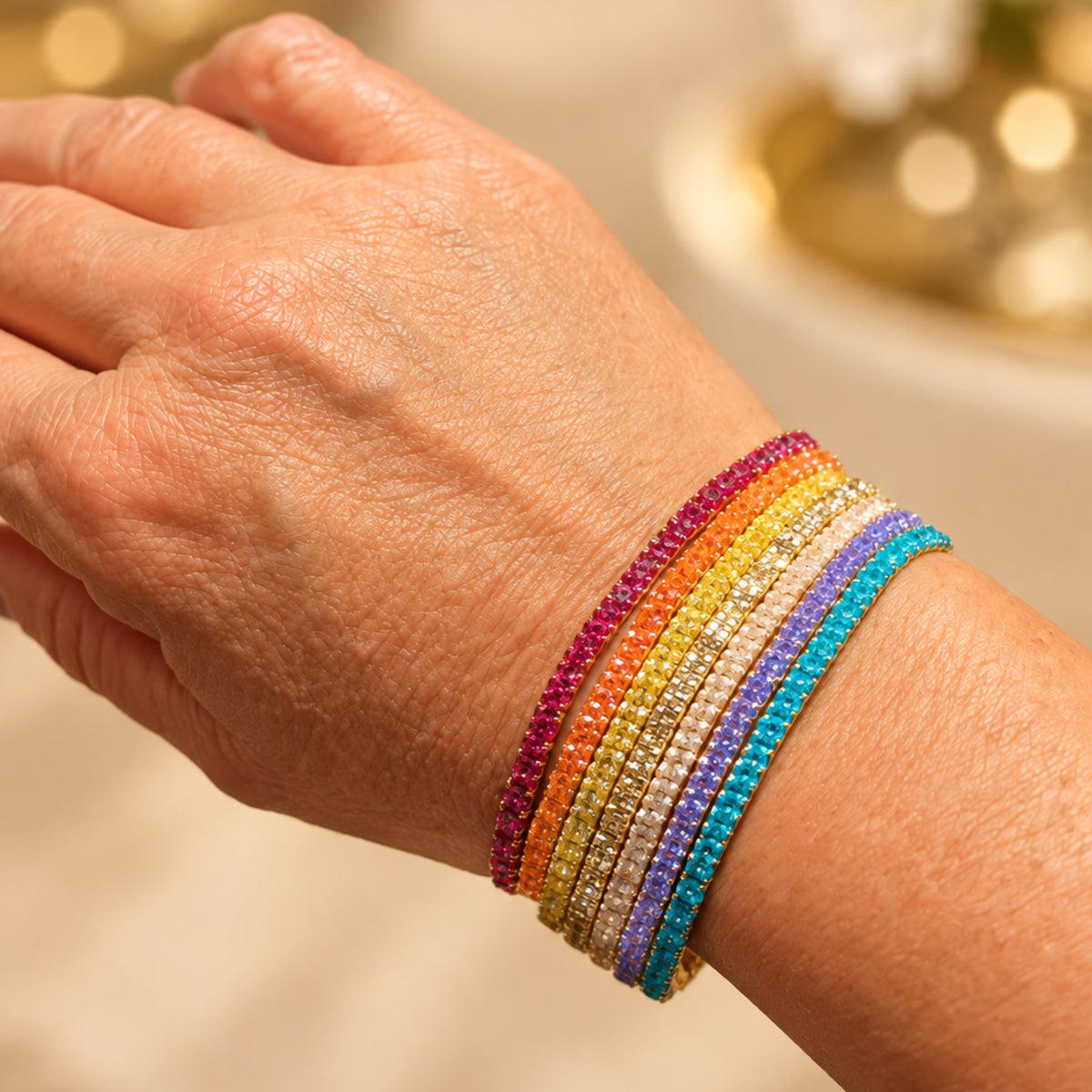 Bracelet Paleta porté au poignet, face à lignes de perles Miyuki turquoise, violettes, orangées et dorées, effet de bracelets superposés.
