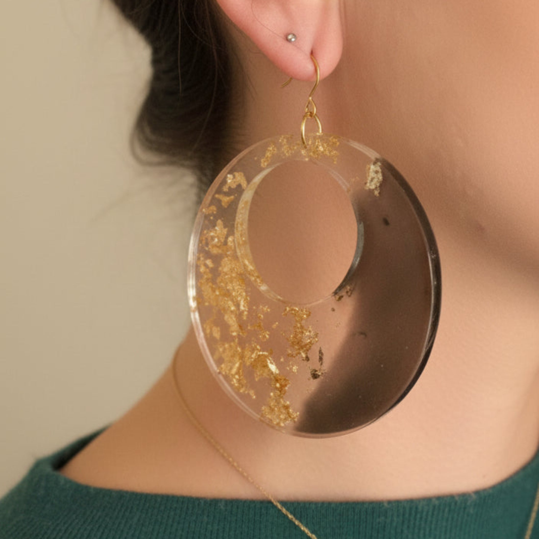 Femme portant les boucles d'oreilles créoles audacieuses ÔParis, bijou fait main en résine noir et or
