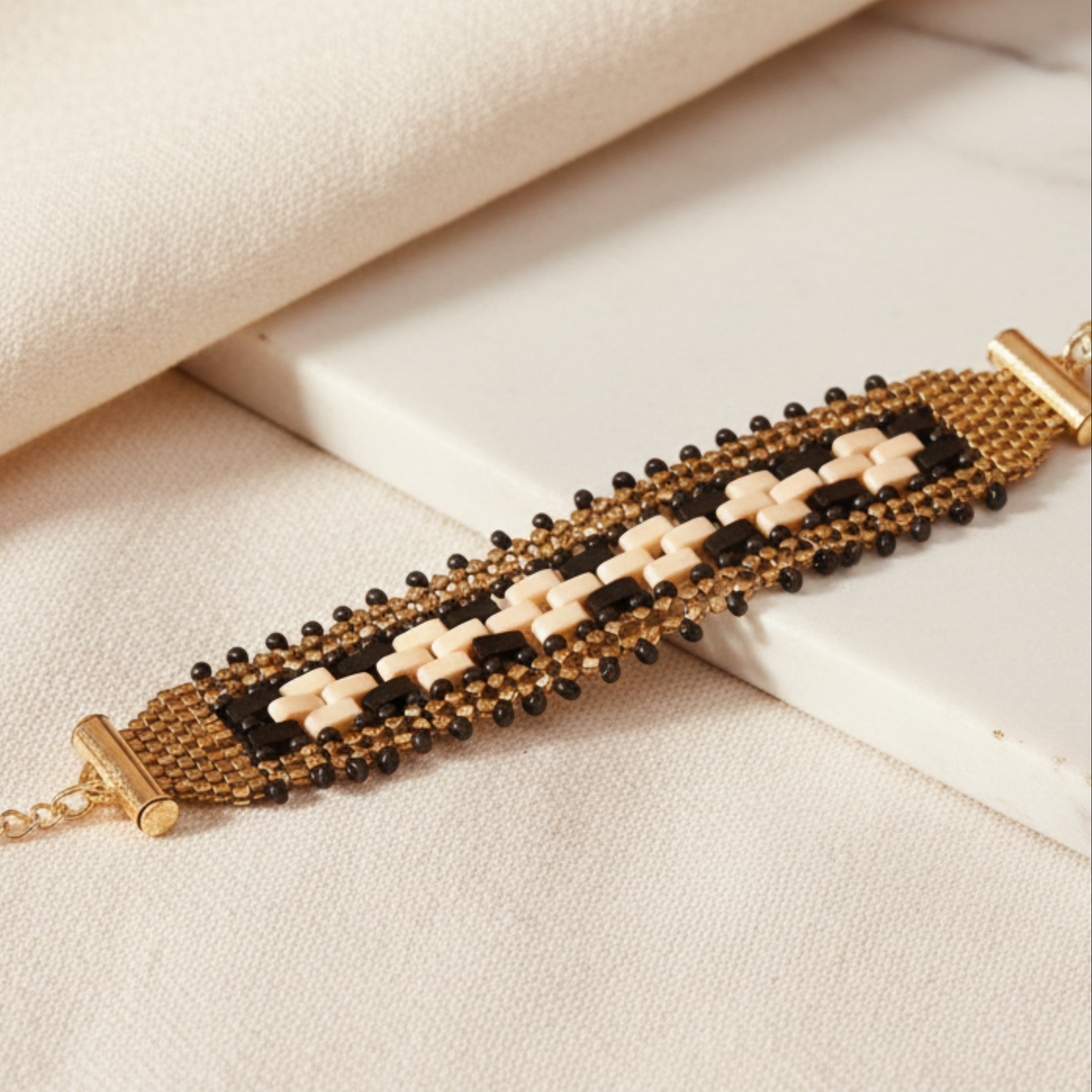 Bracelet précieux ÔParis fait main en perles Miyuki Delica gold et Tila crème et noires, acier inoxydable, 17 cm
