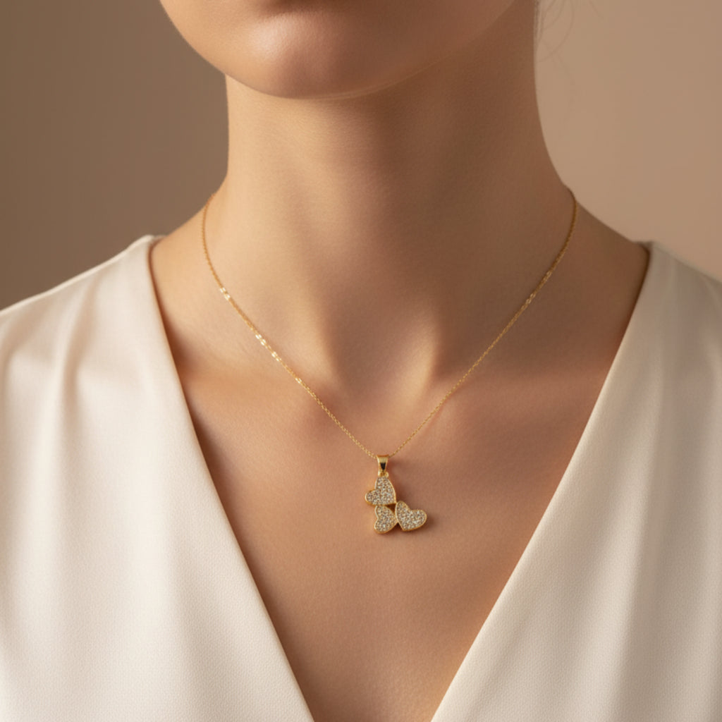 Femme portant le collier Nous 3 - Collier doré trio de cœurs zirconiums
